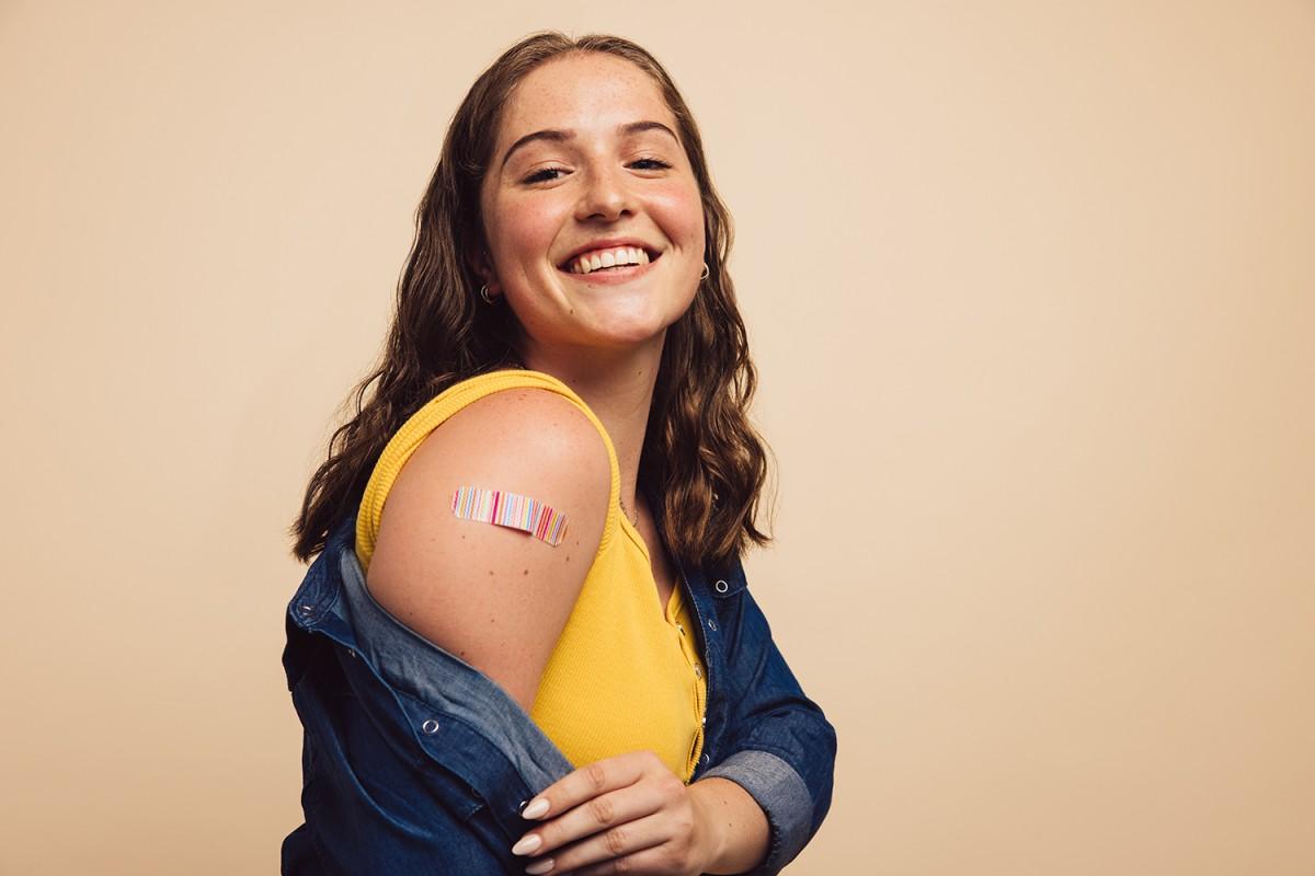 Young adult female posing with band-aid from immunization